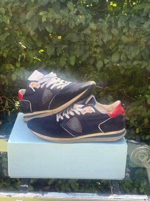 Philippe Model trainers röd/blå  - Säljer ett par Philippe model trainers i färgen blå och röd, (storlek 43). Okej skick på skorna går så klart att rengöra dem bättre för att göra dem ännu snyggare. Fördel med dessa skor att man växer några cm vid användning, perfekt för dig som vill känna dig lite längre.  Snabb leverans | Pris kan diskuteras | vid ytterligare frågor är det bara att skriva 