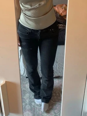Svarta bootcut jeans från ZARA - Säljer ett par mörk grå bootcut jeans från ZARA i storlek 36. Jeansen har klassisk femficksmodell, normalhög midja och lätt utsvängda ben. Snygga till en enkel topp eller hoodie. Materialet är mjukt denim med lite stretch.