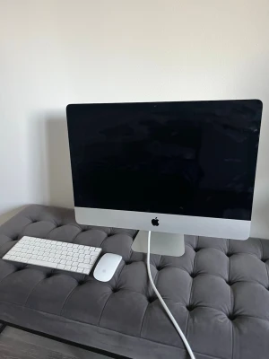 Apple iMac med tangentbord och mus - Säljer en stilren Apple iMac i silver med matchande vitt tangentbord och mus. Datorn har en stor skärm med tunn ram och klassisk minimalistisk design i aluminium. Perfekt för både studier och kreativt arbete.