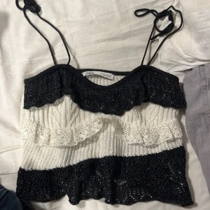 topp zara - super fin topp från zara som kan användas med eller utan band som en bandau topp. Storlek S och köpt i slutet av sommaren så knappt använd! svarta tyget är Glitter. Finns ett litet håll också som inte syns,