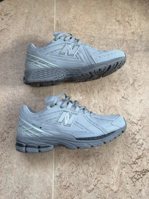 Grå New Balance sneakers - Snygga grå sneakers från New Balance (1906R). Skorna är använda Max 5 gånger, säljer de för att de inte passar så bra, jätte fina skor perfekt skick! 