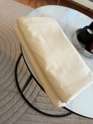 Beige bomullslakan - Säljer ett enkelt och stilrent lakan i beige färg. Materialet är mjuk bomull och lakanet har en slät yta utan mönster. Perfekt till sängen om du vill ha en neutral och fräsch look.