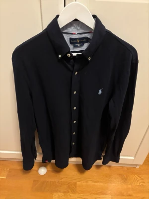 Mörkblå skjorta från Ralph Lauren - En schysst skjorta ifrån Ralph Lauren i marinblå färg, Priset är förhandlingsbart så det är bara att buda på