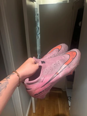 Nike rosa Air Zoom fotbollsskor - Väldigt slitna, elites nu pris är 3399! Skosnörerna är borta men man kan bara köpa nya! Annars är d inte sönder elr så någonstans skorna är stl 47