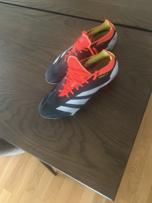 Svarta och orange fotbollsskor - Säljer mina elit fotbolls skor pågrund av att jag får skavsår av dem. Köpta för 2550. Har använt skorna 3 gånger.