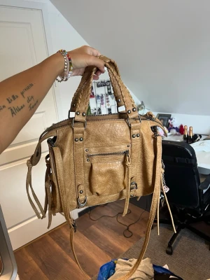 Brun väska - Säljer denna bruna väskan med silverdetaljer från Bershka. Nyskick
