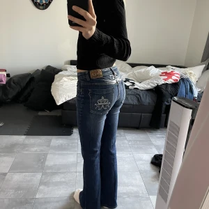 Lågmidjade jeans  - Säljer dessa super coola lågmidjade jeans med tryck på fickorna. Midjemåttet tvärs över är 35 cm men har stretch!!  och innerbenslängden 81cm Skriv vid frågor eller direktköp! Köparen står för frakten💓
