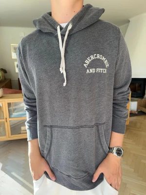  Abercrombie & Fitch hoodie grå herr vintage  - Snygg grå Abercrombie & Fitch hoodie med diskret logga på bröstet. Mjuk och stilren modell med klassisk kangaroo-ficka, vita snören och snygga detaljer. Perfekt vardagshoodie för hösten 🍂 Bra skick!  #Abercrombie #AbercrombieAndFitch #AandF #Hoodie #GreyHoodie #GråHoodie #Preppy #Vintage #Streetwear #Menswear #Herrkläder #Höst