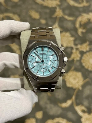 Seiko mod Royal Oak 💙 - Snygg klocka med ljusblå urtavla och kronograffunktion. Boetten är åttakantig i borstat stål och armbandet är i matchande metall med länkdesign. Urtavlan har flera små visare och datumfönster. Perfekt accessoar för dig som gillar modern och sportig stil.