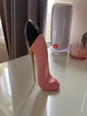 Carolina Herrera parfym  - Unik parfymflaska designad som en högklackad sko i rosa och svart med guldfärgad klack. Flaskan har en elegant och modern look, perfekt som dekoration på sminkbordet. Materialet är glas och plast.
