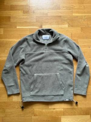 Les Deux Fleece Half-zip - En mycket fin half-zip från LES DEUX i fleece. Grå/grön med dragsko nertill samt i kragen.  Storlek: Small Normal passform med möjlighet att justera Skick: bra skick, inga hål eller fläckar. Lite ”nopprig” se bilder noga!  Har du några frågor eller vill ha fler bilder? Tveka inte på att höra av dig!