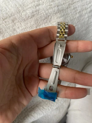 Guldfärgad klocka rostfritt stål manuell - Stilren guldfärgad klocka med klassiskt metallarmband i länkdesign. Klockan har  urtavla och ger en lyxig känsla till din outfit. Perfekt accessoar för dig som gillar tidlös och elegant stil. Boxen ingår i priset