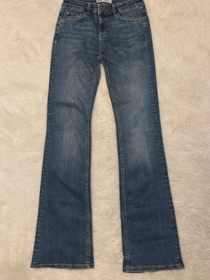 Blå lågmidjade jeans  - Blå lågmidjade jeans från Zara. Gått sönder i ena byxbenet därav priset 