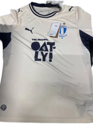 Malmö FF bortatröja Puma vit - Köpte även denna tröja som är en av tre jag köpte som var för någon vecka sedan innan jag åkte på semester. Dum som jag är tog jag inget kvitto och tankte att den skulle passa hur bra som helst. Tyvärr så gör den inte det och jag kan ej lämna tillbaka på butiken. Darför försöker jag salja har. Helt nyskick med lappen kvar och bara testad en gång. De säljer den för 1149 să försöker göra det lite billigare iallafall
