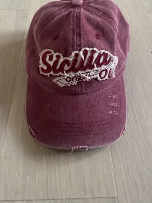 Vinröd keps med Sicilia-brodyr - Säljer en jättefin vinröd keps med vit brodyr❣️ Köpt i Italien📍🇮🇹 pris går att diskutera och köparen står för frakt😇