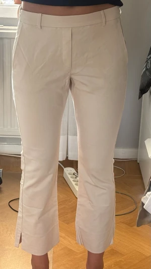 Beiga chinos med slits nertill - Korta beiga byxor med slits. Mycket bra skick!
