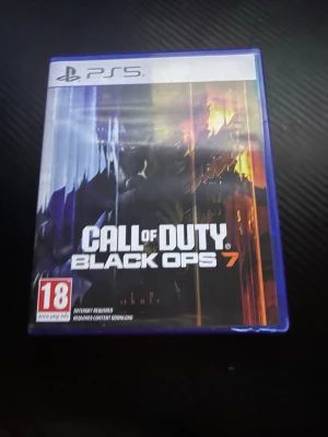Call of Duty Black Ops 7 PS5 - Call of Duty Black Ops 7 till PlayStation 5. Spelet kommer i ett blått plastfodral med omslag i mörka färger och orange detaljer. Inkluderar spel-skiva med samma design som omslaget. Perfekt för dig som gillar action och FPS.