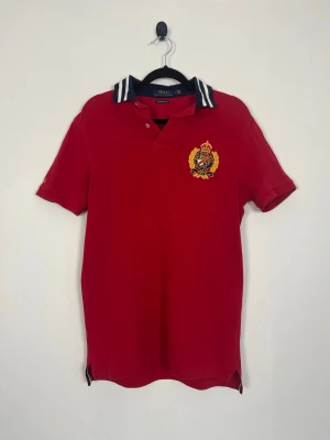 Polo Ralph Lauren Pikétröja Röd Crest Custom Slim Fit Stl S 100% Bomull - Polo Ralph Lauren Pikétröja Röd Crest Custom Slim Fit Stl S 100% Bomull  • Storlek: S • Färg: Röd • Passform: Custom Slim Fit • Krage: Ribbad pikékrage med tvåknapps stängning • Material: 100% bomull  Skick: Plagget är i väldigt fint skick utan defekter. Eventuella anmärkningar anges alltid tydligt i beskrivningen och visas på bilderna.  Nypris: Cirka 1 500 kr.  📦 Skickas snabbt och packas omsorgsfullt. 💬 Hör gärna av dig om du har frågor eller vill se fler bilder. 🤝 Samfrakt erbjuds vid köp av 
