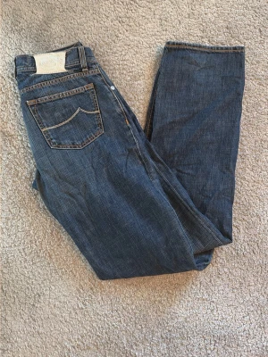Mörkblå jeans från Jacob Cohen - Säljer ett par mörkblå jeans från Jacob Cohen, modell Type 620. Klassisk femficksdesign med kontrastsömmar och knappgylf. Jeansen har en rak passform och är tillverkade i ett slitstarkt denimtyg. Perfekta för en avslappnad och snygg look.