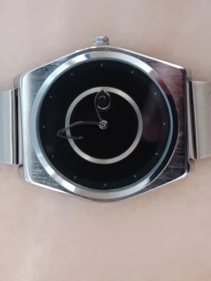 🌀 Unik Retro-Klocka i Silver – Abstrakt "Art"-Design! 💿 - Säljer en sjukt stilren och unik klocka för dig som gillar minimalism med en twist. Perfekt detalj för en clean, vintage-inspirerad outfit! Ett klassiskt, platt länkarmband i retrostil som sitter superbekvämt och ger den där perfekta 90-talskänslan.