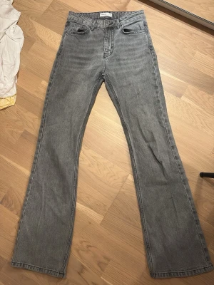 Gråa bootcut jeans - Snygga grå bootcut och klassisk. Jeansen är midwaist, tillverkade i ett mjukt denimtyg som ger en avslappnad look. 