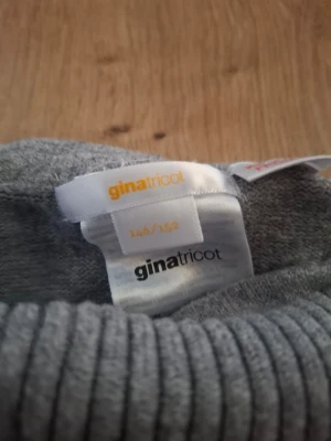 Grå ribbade leggings Gina Tricot - Mysiga grå leggings från Gina Tricot med bred ribbad midja och raka ben. Tillverkade i mjukt stretchigt material som sitter skönt på kroppen. Perfekta för en avslappnad och trendig look.