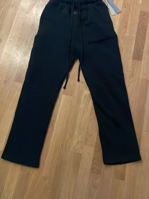 Svarta Essentials mjukisbyxor - Säljer ett par svarta mjukisbyxor från Essentials. Anledning till att jag säljer dom är för att dom var för stora på mig. Helt nya och oanvända.