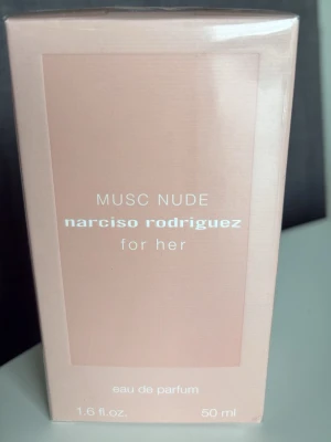 Musc Nude Narciso Rodriguez parfym - Musc Nude från Narciso Rodriguez for her är en eau de parfum i en elegant, ljusrosa rektangulär förpackning. Doften är feminin och exklusiv, perfekt för dig som gillar mjuka och sensuella toner. Flaskan rymmer 50 ml och har en stilren design.