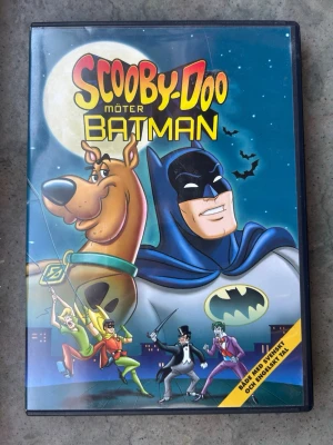 Scooby doo möter Batman dvd - DVD-film med Scooby-Doo och Batman. Textning: Svenska, danska, norska, finska, engelska. Speltid: 78 minuter. Bildformat: 1.33:1.  Finns på språk: Svenska, Danska, Norska, Engelska    OBS!! skivorna är begagnade så det kan förekomma repor/hairlines på skivorna, men då jag kollar igenom alla filmer jag säljer garanterar jag att alla funkar felfritt om inget annat står! :)