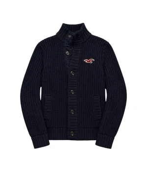 Mörkblå stickad cordigan Hollister - Mörkblå stickad kofta från Hollister med hög krage och knappar framtill. Koftan har ribbade muddar, två fickor och Hollisters ikoniska logga i rött och vitt på bröstet