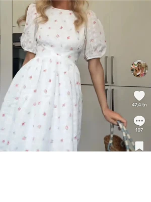 Vit blommig kortklänning med puffärm - Supersöt vit kortklänning med små rosa blommor, puffärmar och öppen rygg. Klänningen har en markerad midja och en lätt utsvängd kjol. Perfekt för sommarens alla tillfällen och ger en romantisk vibe. Pris går att diskuteras 😊
