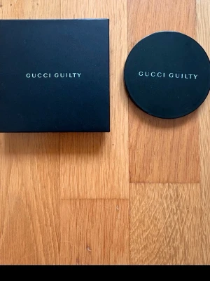 Gucci Guilty svart presentask - Snygg svart presentask från Gucci Guilty med tillhörande rund ask. Båda askarna är i hård kartong med stilren logga i vitt. Perfekt för att förvara smycken, småprylar eller som gåvoförpackning.100 procent äkta jag lovar!😎👍🏽köp jag behöver få sålt den och jag vet it vad jag ska ha den till och de är rea på den ny pris mellan 1000 och 1500kr 💯💯🙏🙏 Den är från glossybox!100 procent äkta💯💯💯💯💯Du som köper får 20kr med på köpet jag har ingen användning av den alls man får med box och och 20kr 💯 