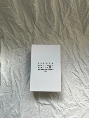 Maison Margiela blå sneakers - Snygga blå sneakers från Maison Martin Margiela med vita snören och klassisk siluett. Skorna har en stilren design med ovandel i mocka och läder, samt diskreta detaljer som ger en exklusiv känsla. Perfekta för dig som gillar minimalistisk och trendig stil. Dem kommer i orginialboxen och allt ingår. 