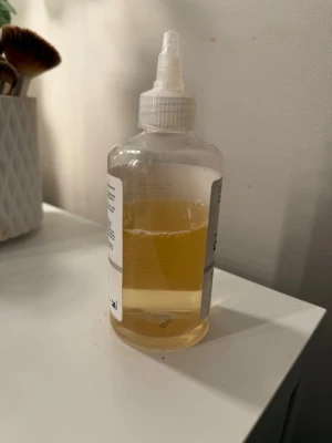 The Ordinary Glycolic Acid 7% Toner - The Ordinary Glycolic Acid 7% Exfoliating Toner i en genomskinlig plastflaska med vit etikett och snedställd applikator. Tonern är ljusgul och används för att exfoliera och förbättra hudens struktur. Perfekt för dig som vill ha en fräschare och klarare hy.