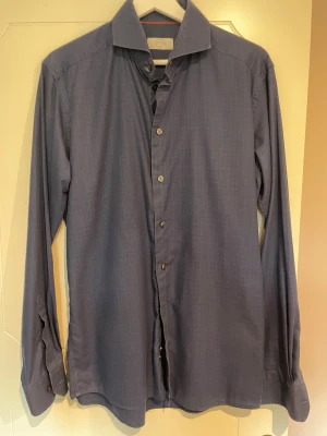 Mörkblå rutig skjorta från Eton, slimfit strl 40 - Snygg mörkblå skjorta från Eton med diskret rutigt mönster. Slim fit och storlek 40. Perfekt för dig som gillar stilrena och tidlösa plagg.