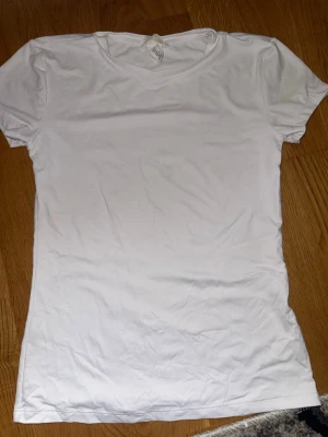 Vit basic t-shirt soft touch  - En klassisk vit t-shirt med rund hals och korta ärmar. Tillverkad i mjukt material som passar perfekt till alla outfits. Enkel och stilren design utan tryck eller mönster. Har en fläck men inget som syns jättemycket. 