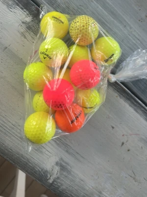 Färgglada golfbollar  - Ett gäng golfbollar i olika färger, mestadels gula men även några orangea och rosa. 