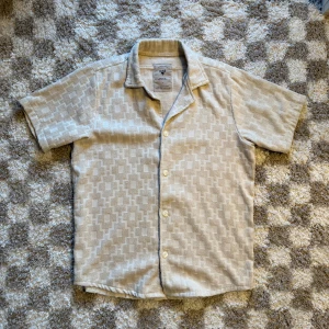 Terryskjorta från OAS, L - Säljer en beige terryskjorta från OAS i storlek L, tillverkad i 100% mjuk frotté-bomull. En riktig strandskjorta ”Made to use right after swim”. Använd ett fåtal gånger. Lång i modellen.