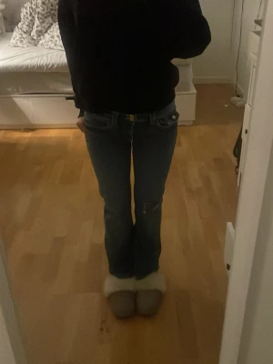 Blå bootcut jeans från Gina Tricot - Säljer ett par blå jeans från Gina Tricot i storlek 164. Modellen har bootcut-ben och låg midja, med klassiska fickor och egenklippt hål i knät💗