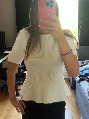Vit ribbad topp med volang - Jättesnygg stickad topp med volang från hm, använd endast nåra få gånger 