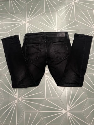 Svarta Jack & Jones Jeans - Säljer ett par svarta J&J Jeans i modellen Slim Glenn. De har en snygg tvättad fade och raka ben. Storlek: W30 L30. Inga defekter. Skriv om du har en fråga!✌️