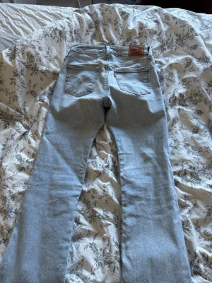 Ljusblå bootcut jeans från Levi's - Säljer ett par ljusblåa lågmidjade bootcut jeans från Levi's. Knappt använda 