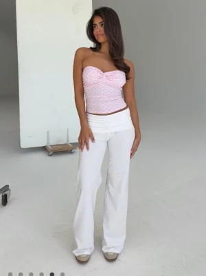 Vita bootcut leggings med hög midja - Säljer ett par vita yoga pants  med bootcut-modell och bred, medel hög midja. De är stretchiga och har en mjuk, följsam passform som sitter snyggt på kroppen. Perfekta till crop tops eller oversized tröjor för en trendig look.
