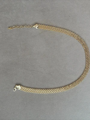 Viral x halsband  - Snyggt armband i guldfärgad metall med tät kedjedesign. Armbandet har en justerbar kedja och karbinlås för enkel användning. Perfekt för dig som gillar stilrena accessoarer med lite extra glans.