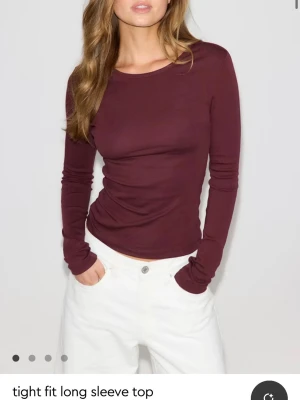 Vinröd långärmad topp - Säljer en vinröd långärmad topp i tight passform. Toppen har rund halsringning och är gjord i ett mjukt material som känns skönt mot huden. Perfekt att styla med jeans eller kjol för en enkel och snygg look.