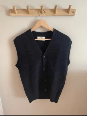 Väst med knappar Zara - Säljer en mörkblå väst med knappar från Zara. Västen kommer från deras Zara orgins kollektion. Den är helt oanvänd, väldigt fint skick! Skönt material: 70% ull och 30% alpacka. Storleken är true to size.   
