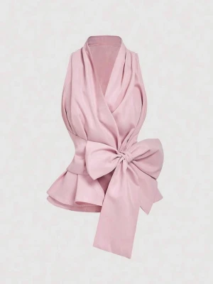 Rosa omlottopp med stor rosett - Supersnygg rosa omlottopp med en stor rosett i midjan och volang nedtill. Toppen är ärmlös och har en elegant v-ringning. Perfekt för dig som vill sticka ut med en feminin och trendig look.