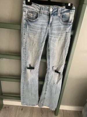 Ljusa slitna jeans från Gina Tricot - Säljer ett par ljusblå jeans från Gina Tricot med raka ben och slitningar vid knäna. Jeansen har klassisk femficksmodell och är tillverkade i denim. Perfekta för en avslappnad och trendig look.