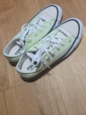 Ljusgröna Converse All Star låga - Låga Converse All Star sneakers i ljusgrönt canvasmaterial med vita snören och tå. Klassisk svart rand runt sulan och tydlig logga på plösen. Perfekt för dig som gillar stilrena och tidlösa sneakers.