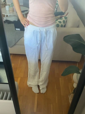 Vita linnebyxor med resårmidja - Säljer ett par vita linnebyxor med avslappnad passform och resår i midjan. Byxorna har raka ben och är knappt använda. Storlek Xs från Lager 157. 💞